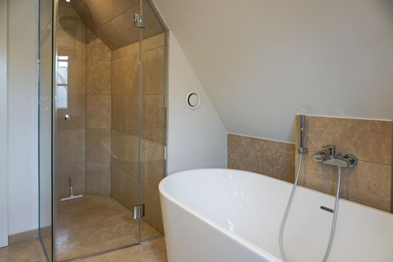 Bath with freestanding bathtub and shower with glass enclosure.