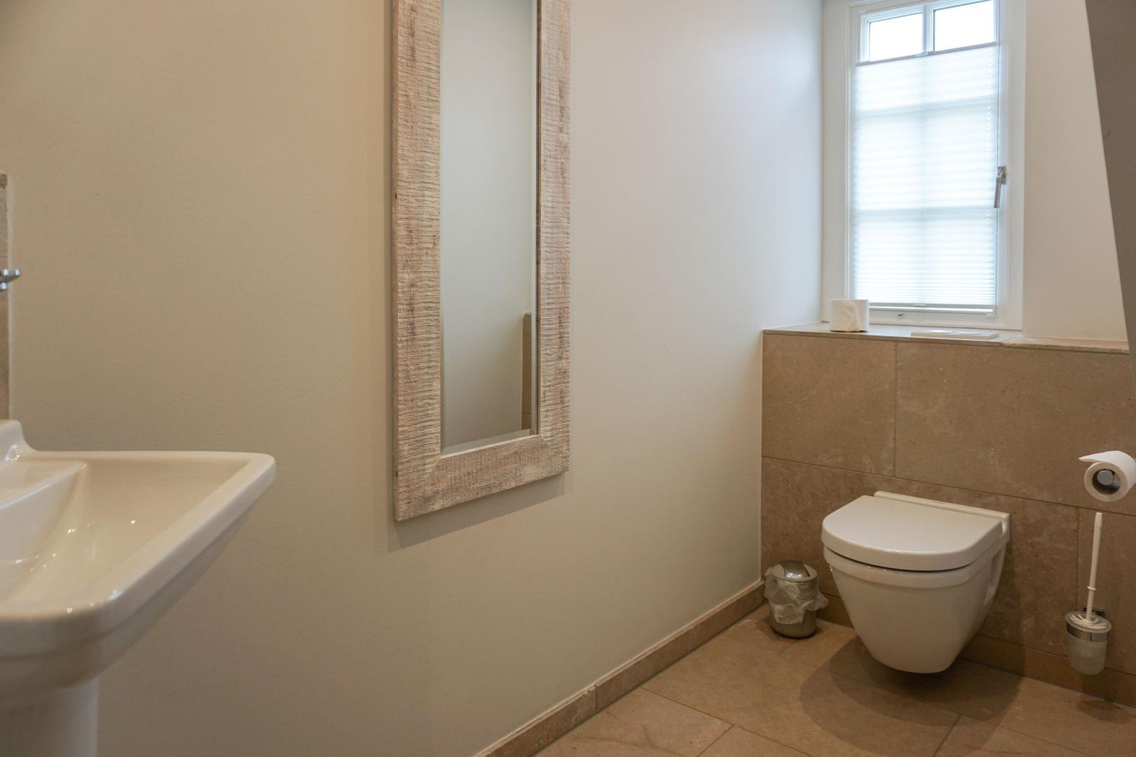 Bathroom with mirror, toilet, and sink.