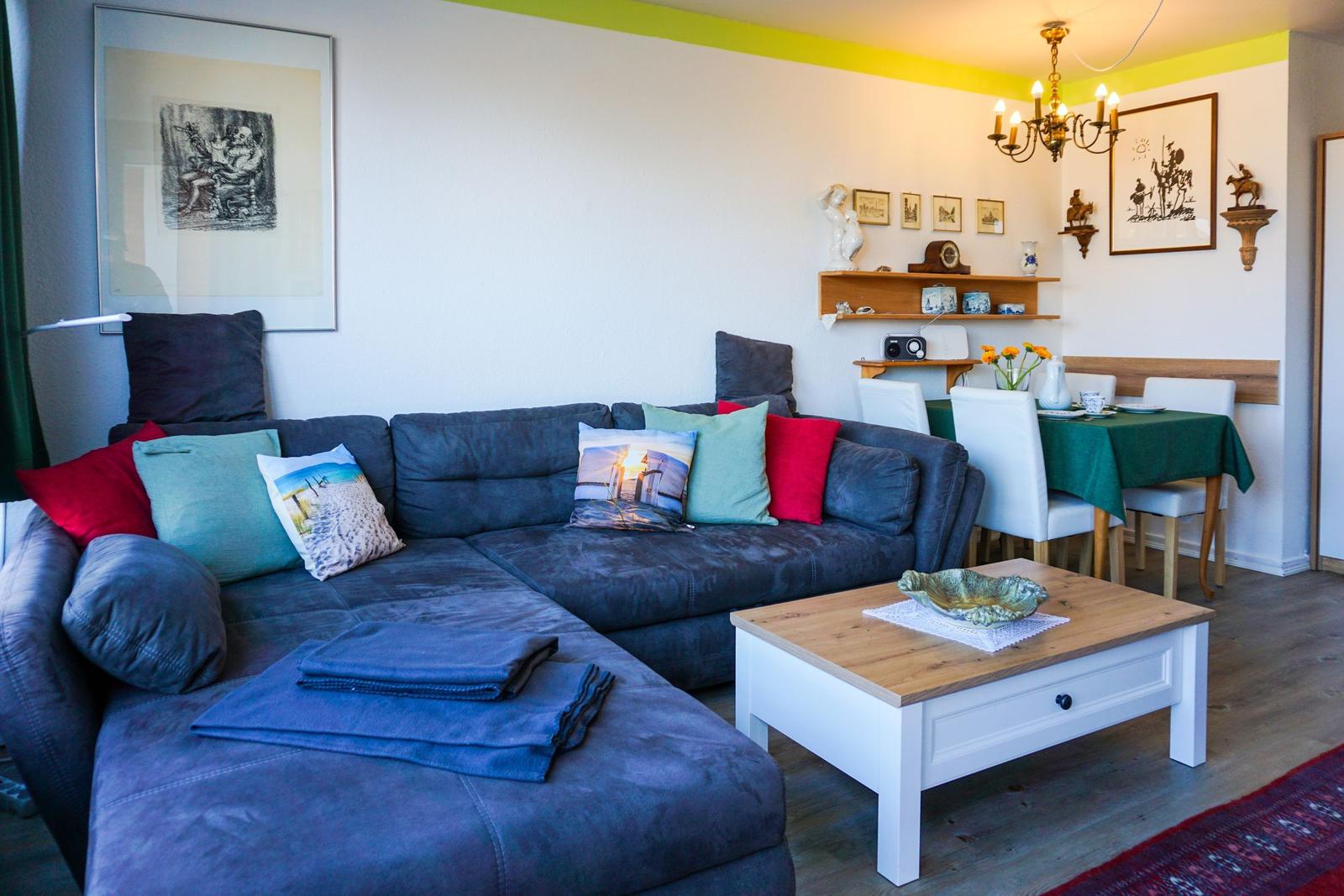 Wohn- und Essbereich mit Sofa, Tisch und Wanddekoration.