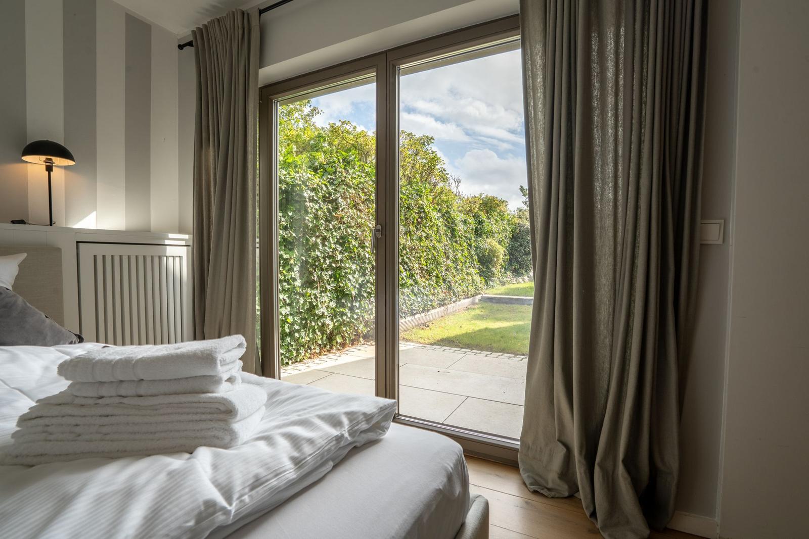 Schlafzimmer mit Blick auf Garten durch Glastür