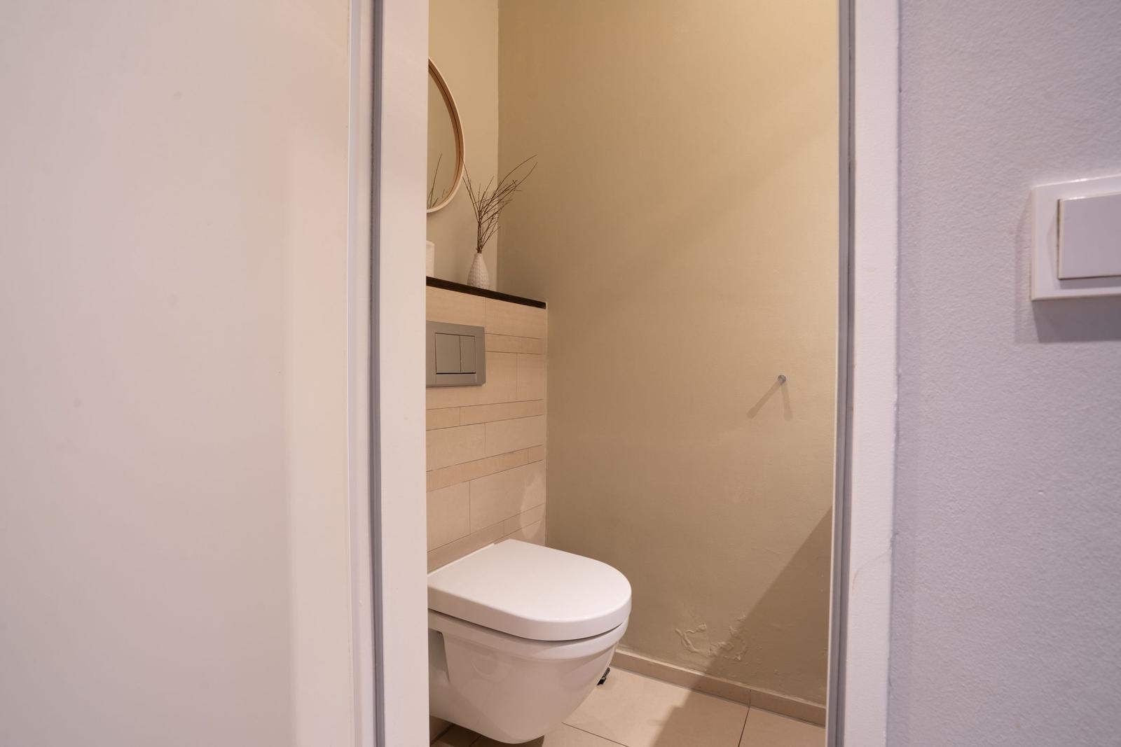 Toilettenraum mit Wandspiegel und Vasen