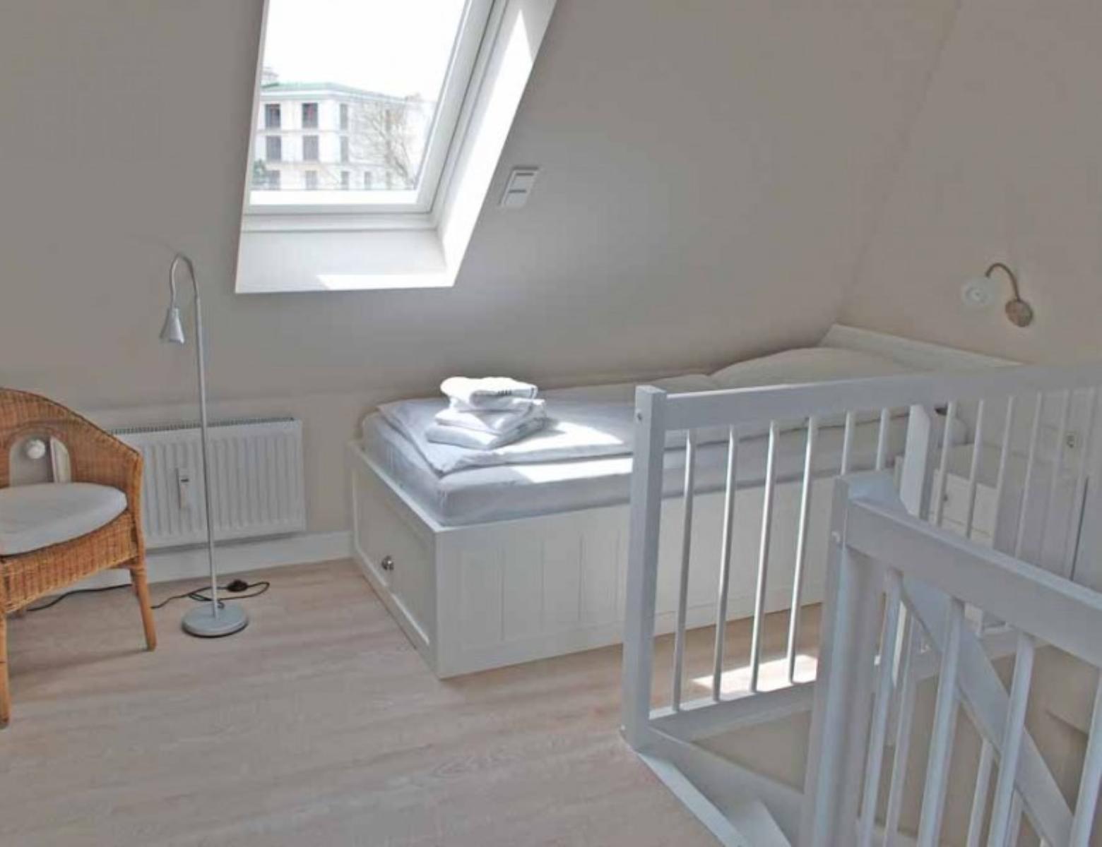 Room with crib, bed, and window
