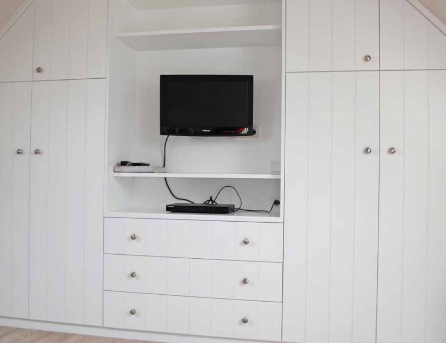 Wall unit with TV and drawers in the bedroom.