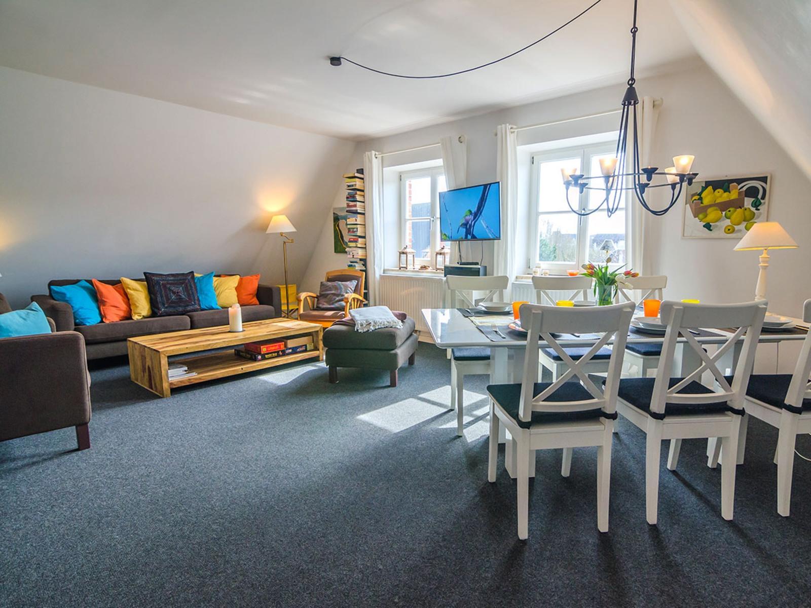 Living and dining area with sofa, dining table, and windows.