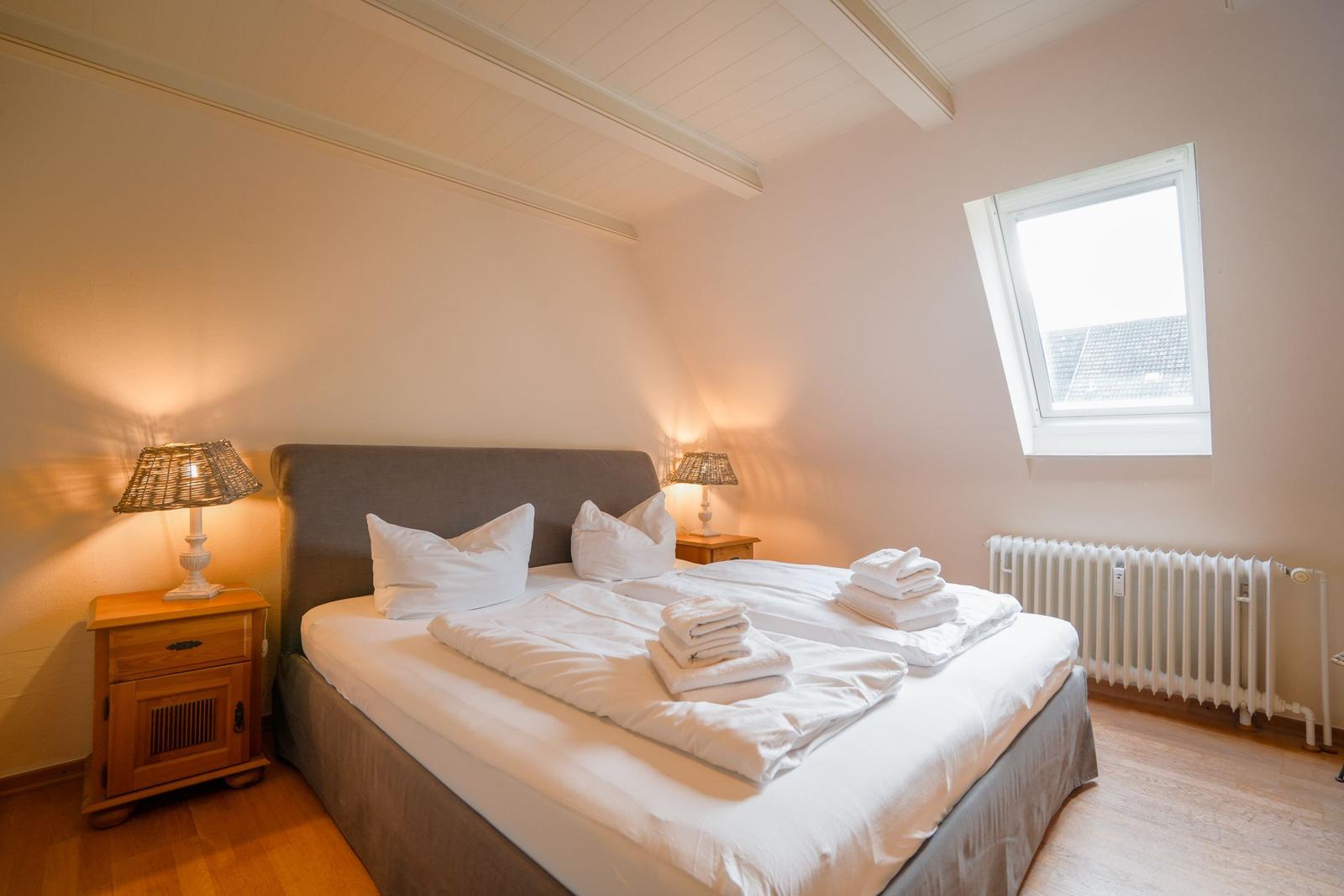 Bedroom with double bed, two nightstands, and skylight.