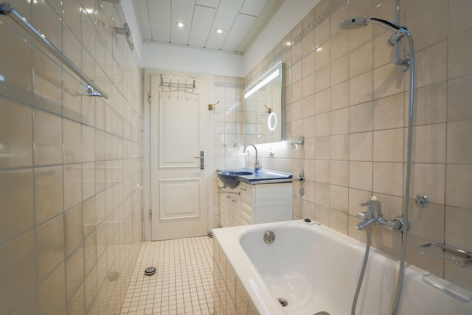 Bathroom with bathtub, shower, and sink