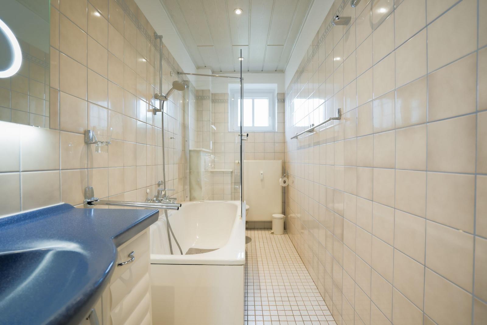 Bathroom with bathtub, shower, and sink.