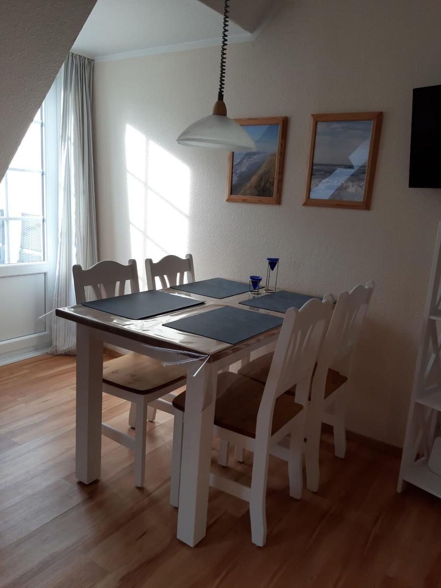 Dining area with table, four chairs, and pendant light.
