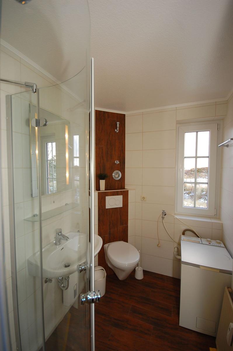 Bathroom with shower, toilet, and washing machine.