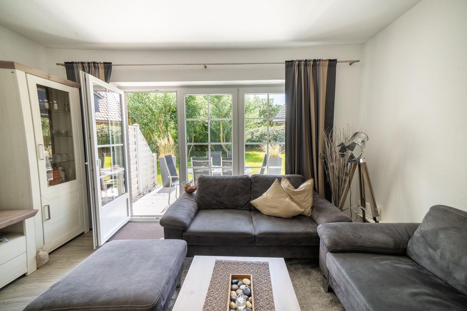 Wohnzimmer mit Sofa, Sitzbank und Terrassentür.