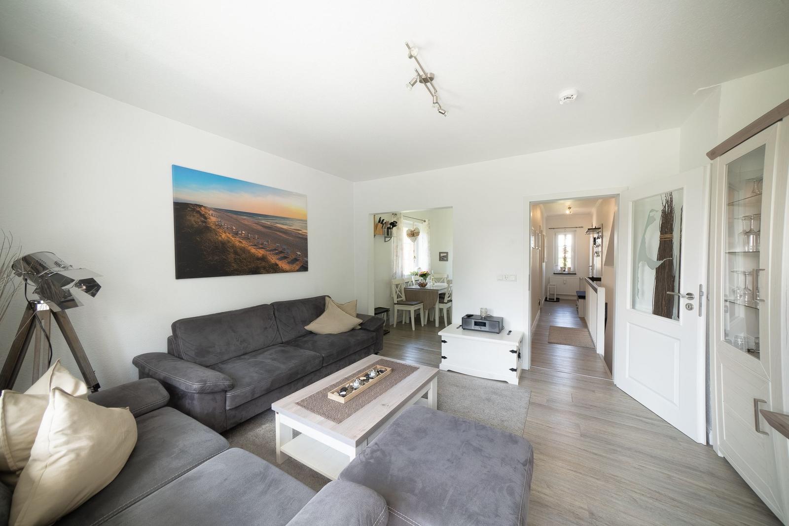 Wohnzimmer mit Sofa, Couchtisch und Blick in Essbereich.