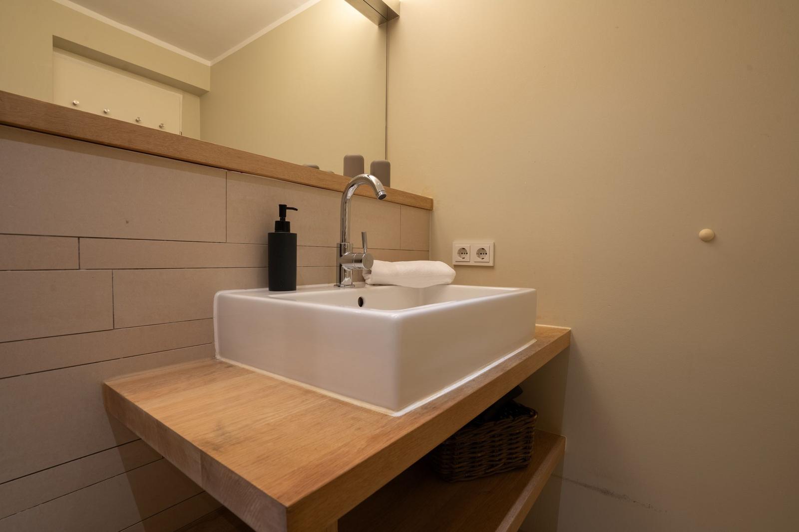 Sink on wooden vanity with mirror and towel