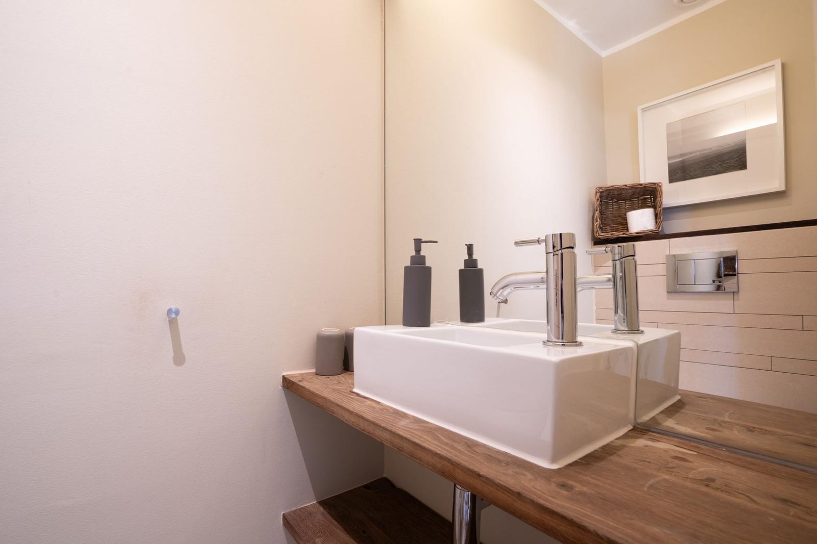 Sink with two faucets on wooden vanity