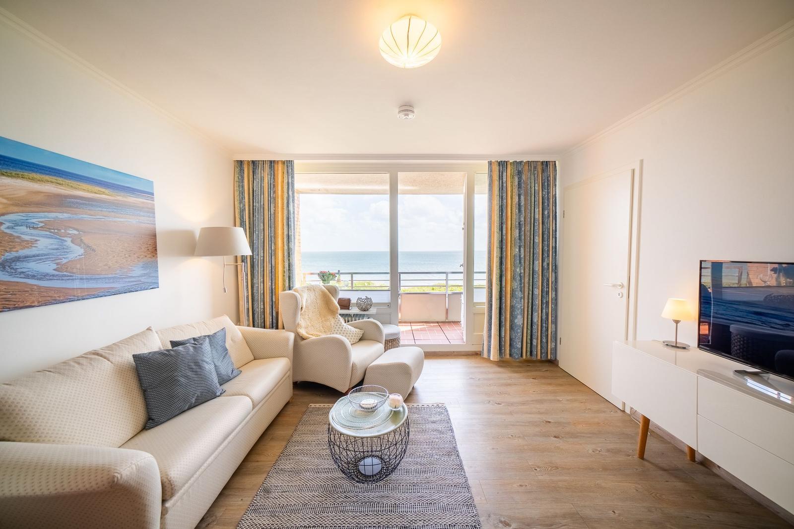 Living room with sofa, armchair, and sea view