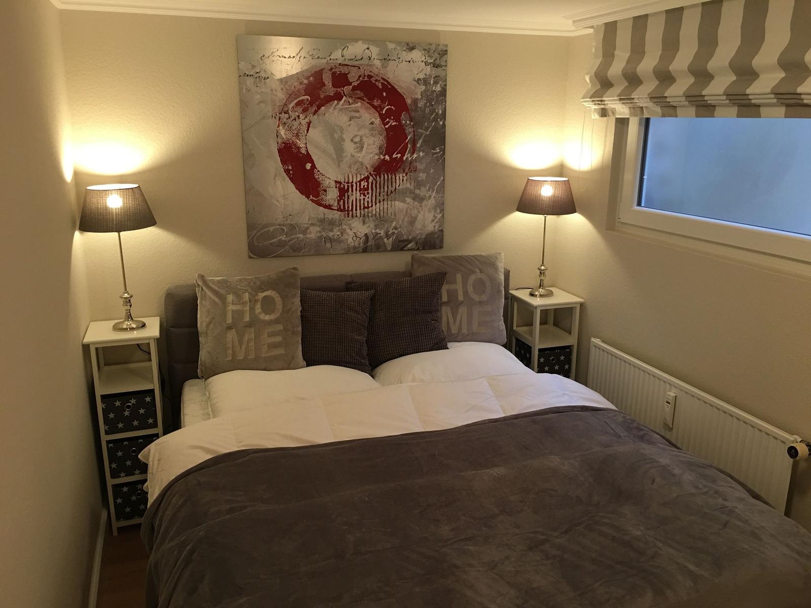 Schlafzimmer mit Bett, zwei Nachttischen und Wandbild