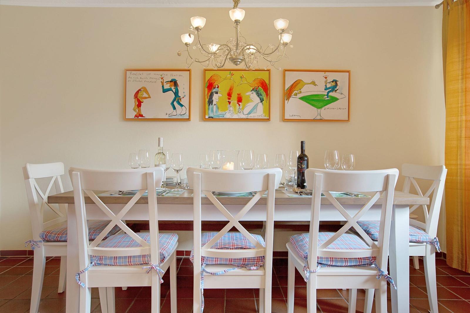 Dining room with table, chairs, and wall art.