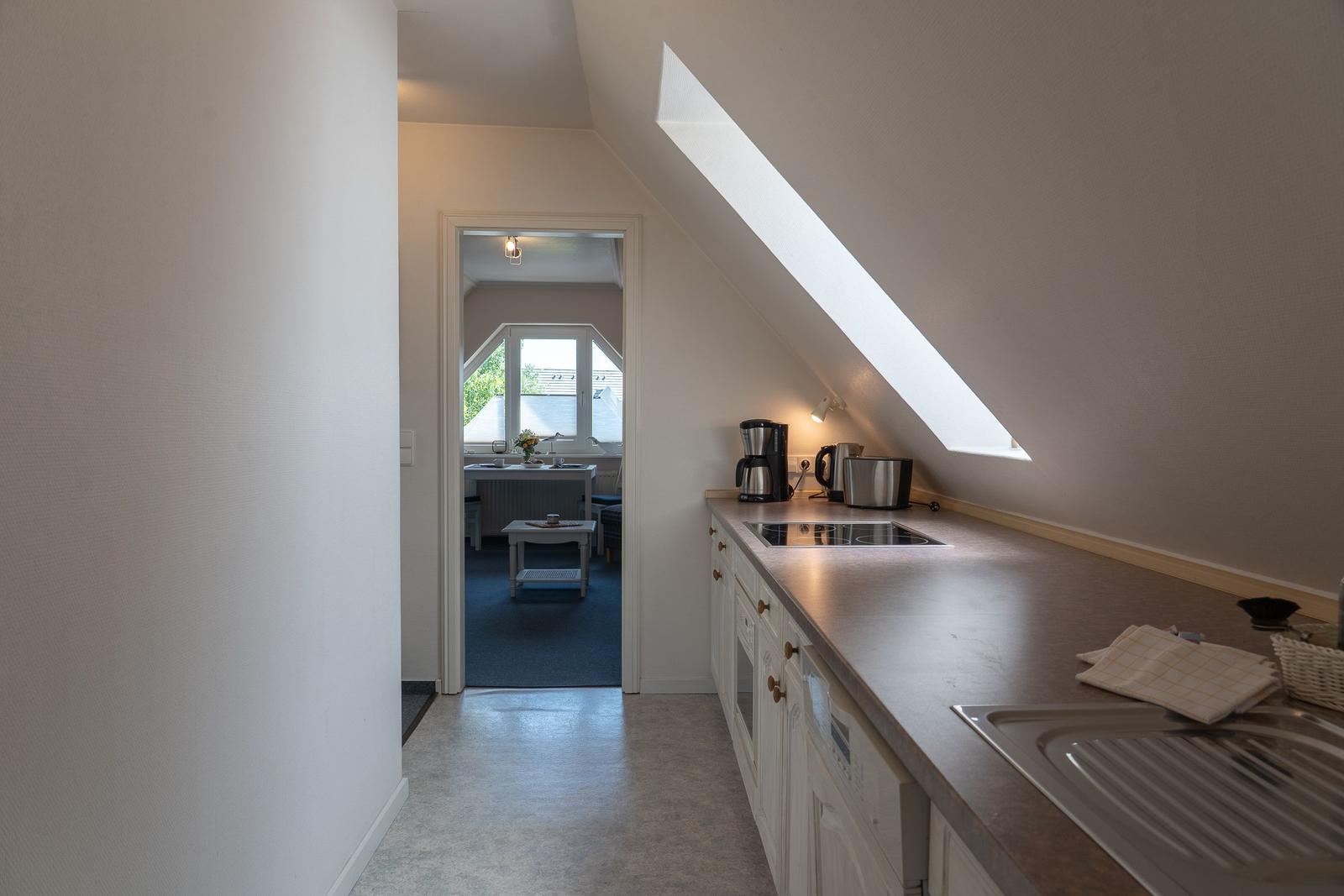 Küche mit Dunstabzug, Kaffeemaschine und Blick in Wohnzimmer