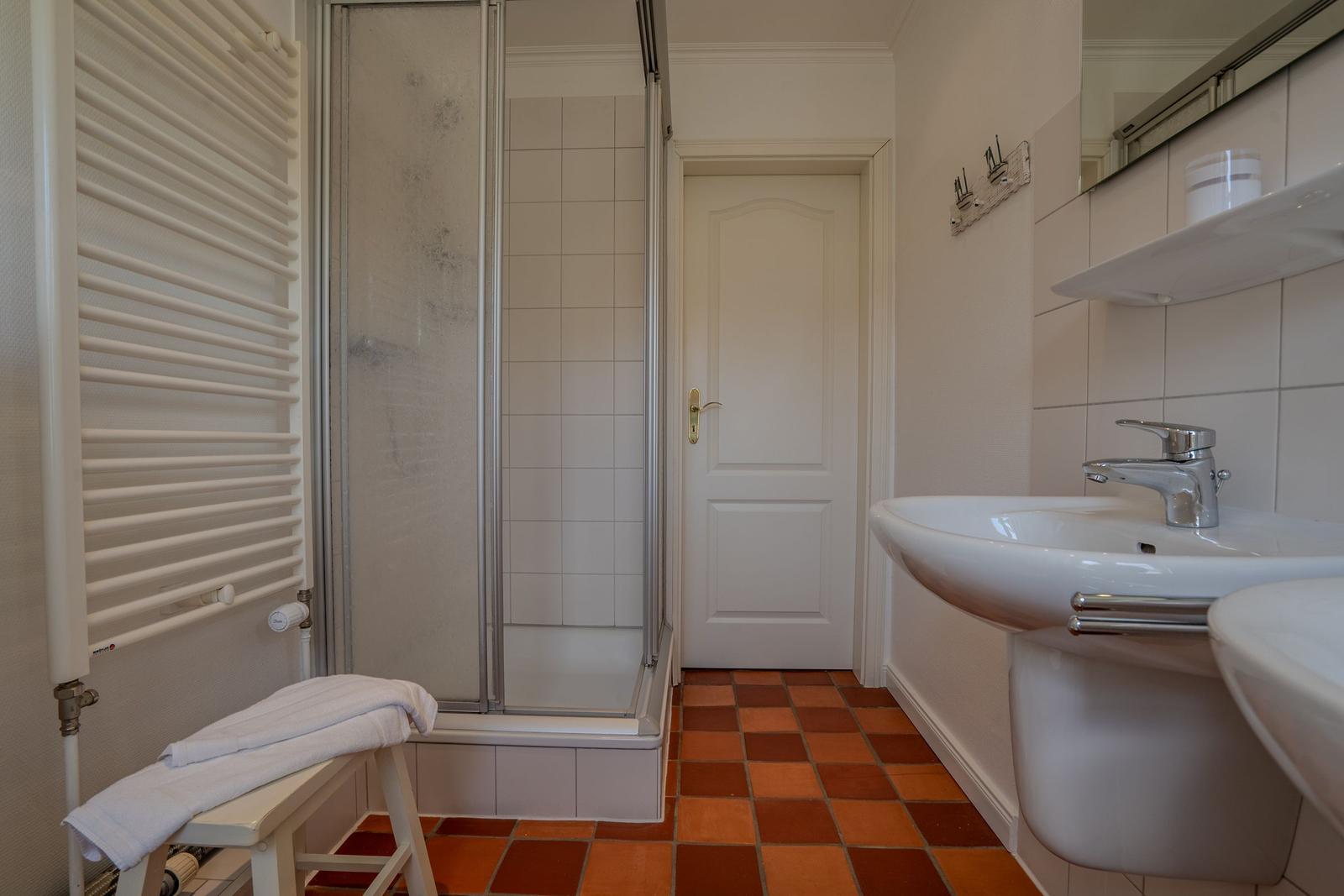 Bathroom with shower, sink, and heater.