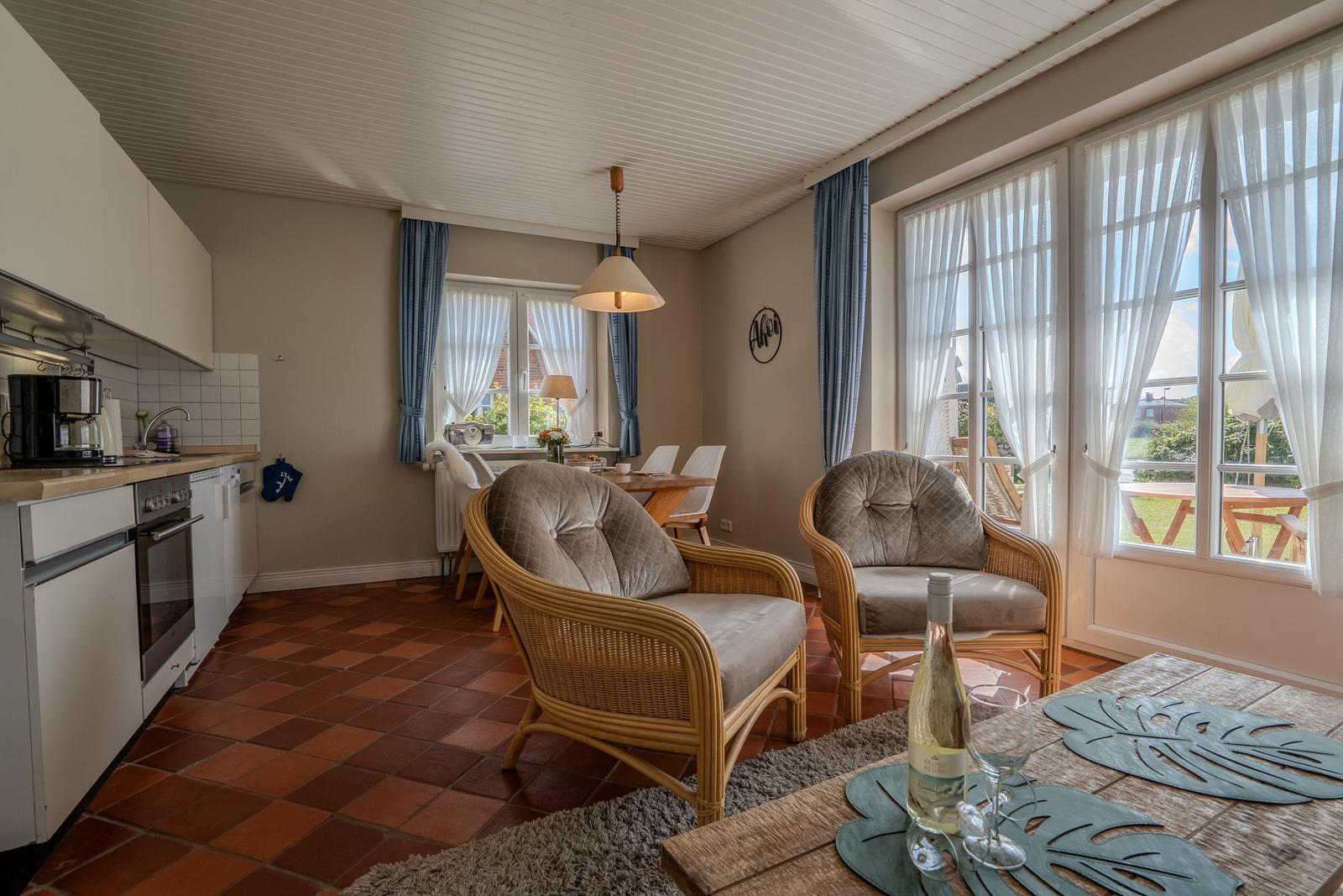 Kitchen, dining area, and seating with view to the terrace.