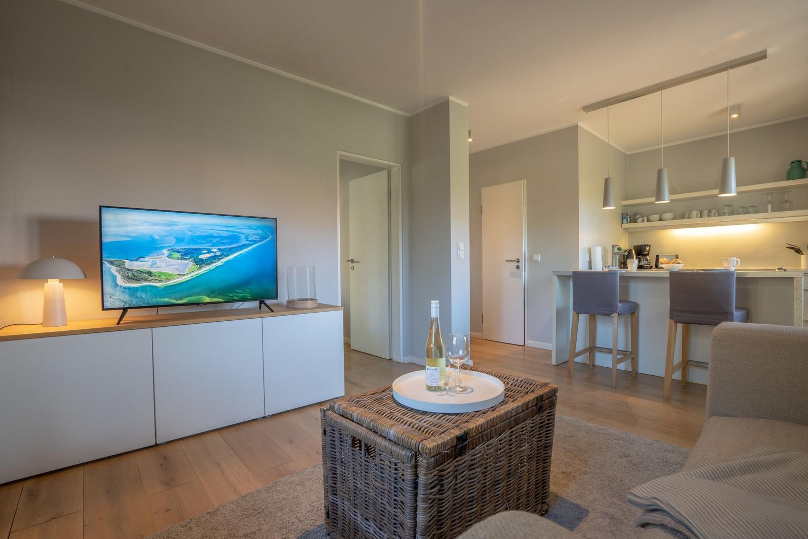 Wohnbereich mit TV, Esstisch und Küchenbereich.
