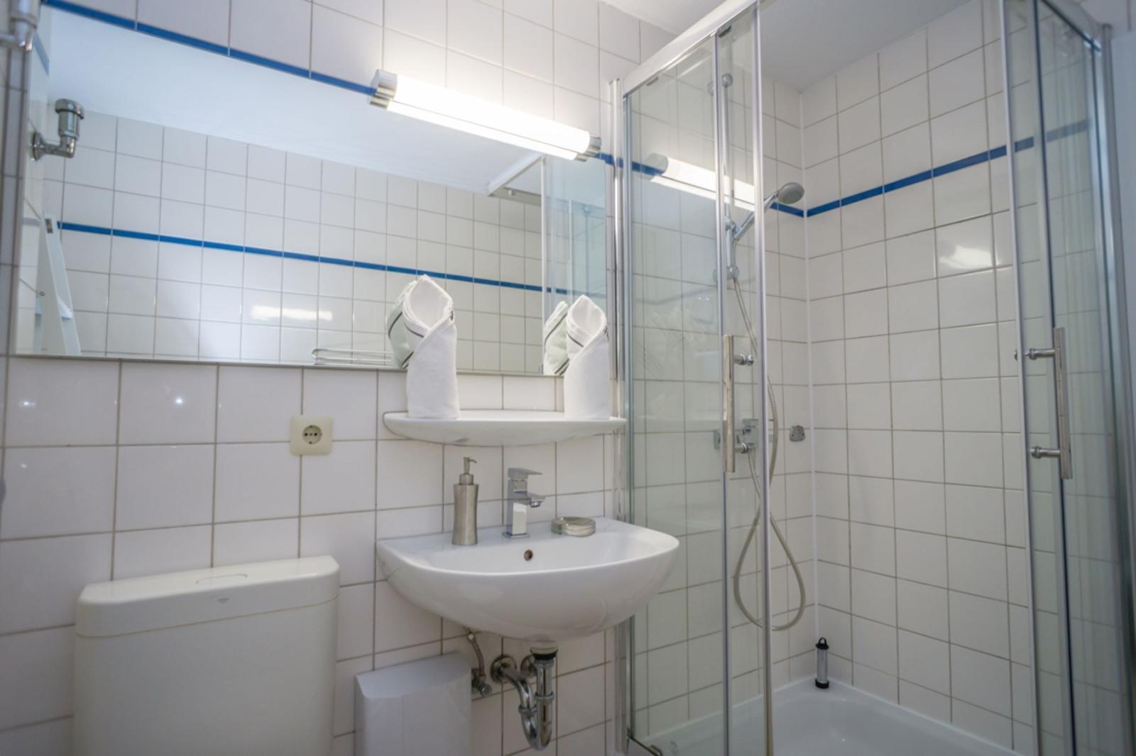Bathroom with shower, sink, and mirror