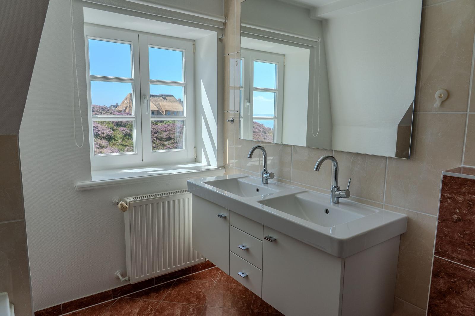 Badezimmer mit Doppelwaschbecken und Fenster