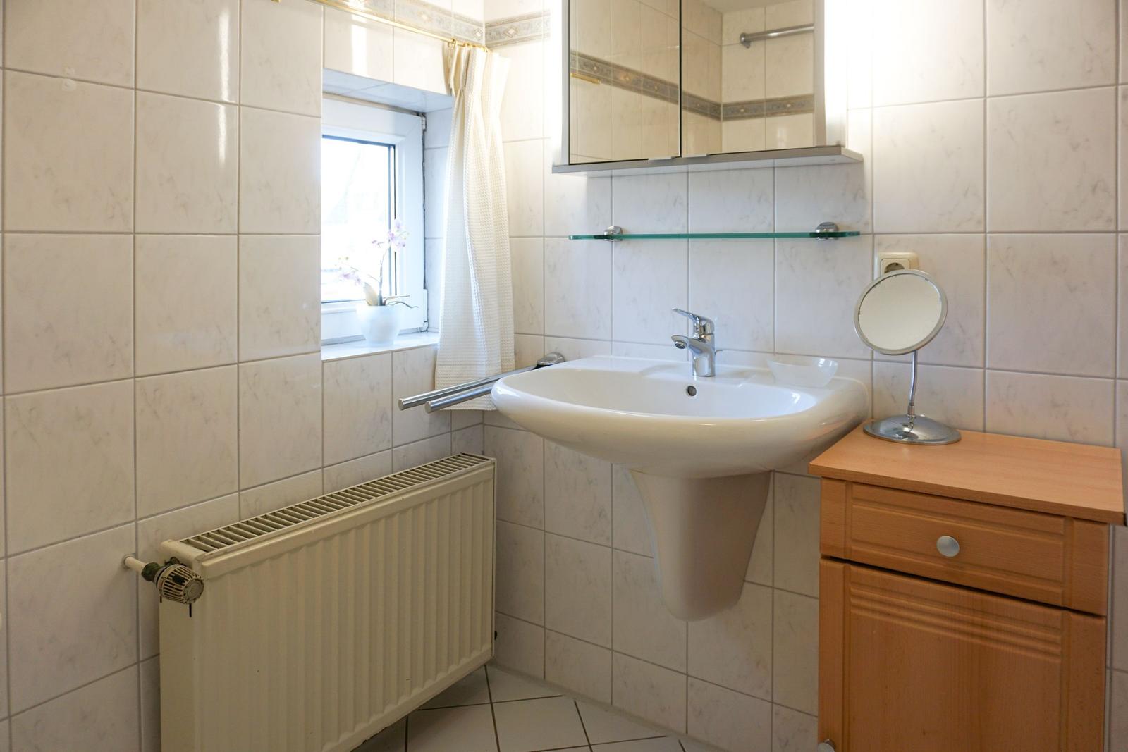 Bathroom with sink, mirror, and window
