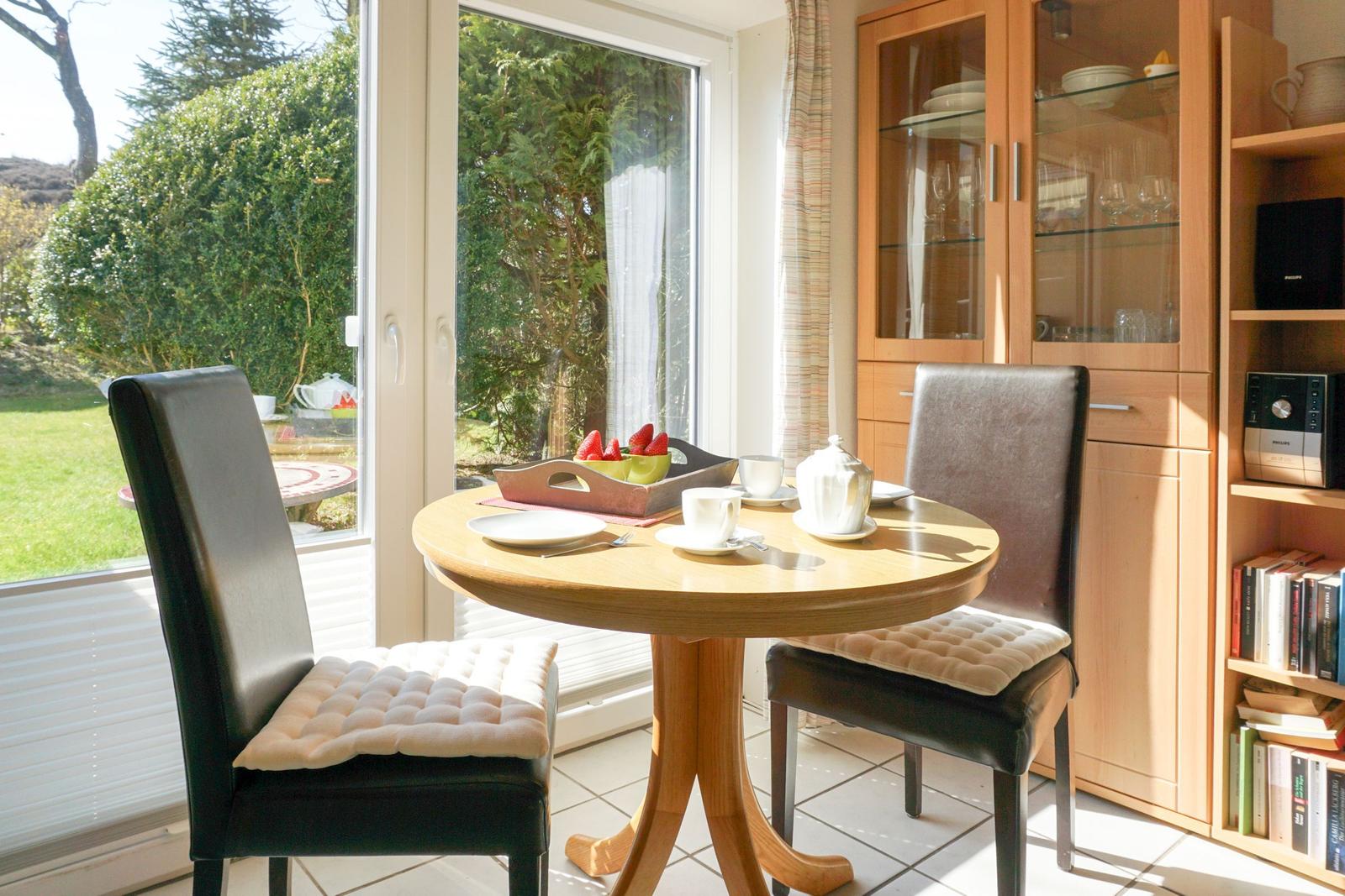 Round dining room with table, chairs, and garden view.