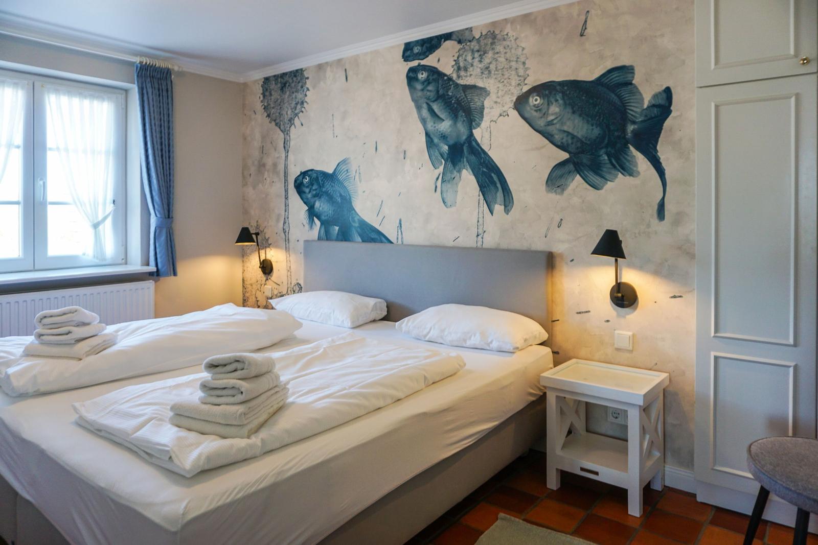 Bedroom with bed, fish wall mural, and nightstand.