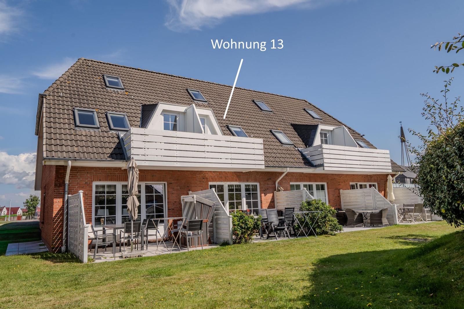 Wohnung 13 mit Balkon, Terrasse und Garten. Mehrere Fenster und Dachgauben.