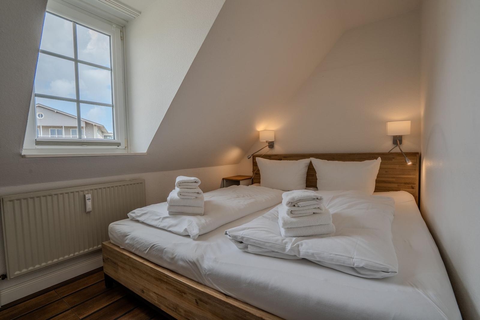 Schlafzimmer mit Doppelbett, Fenster und Holzboden
