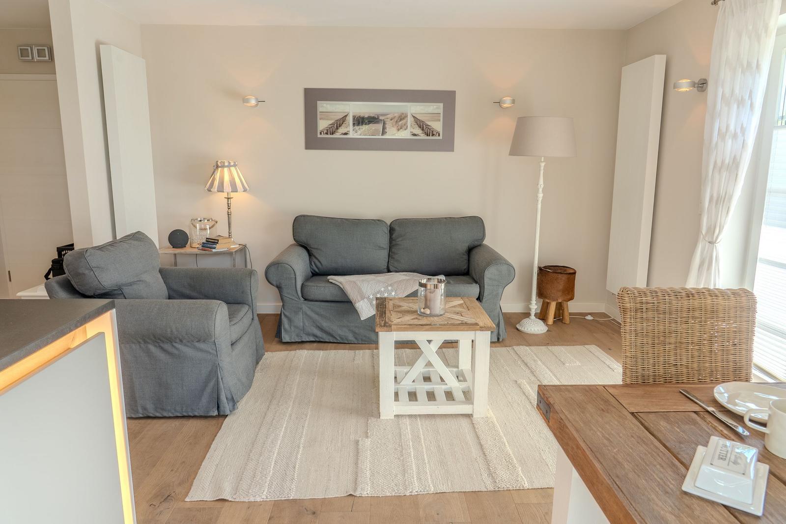Wohnzimmer mit grauem Sofa, Holzfußboden und Esstisch