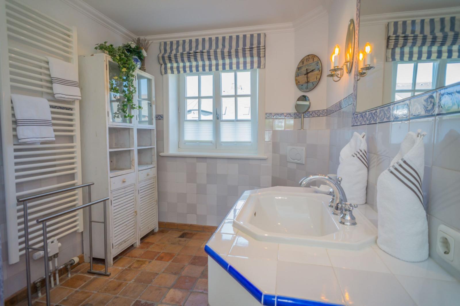 Badezimmer mit Badewanne, Fenster und Handtuchhalter