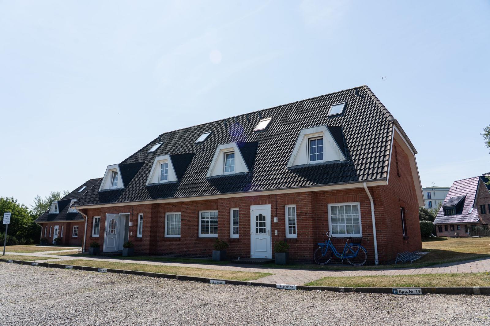 Rotes Backsteinhaus mit Dachgauben und Fahrrad vor der Tür.