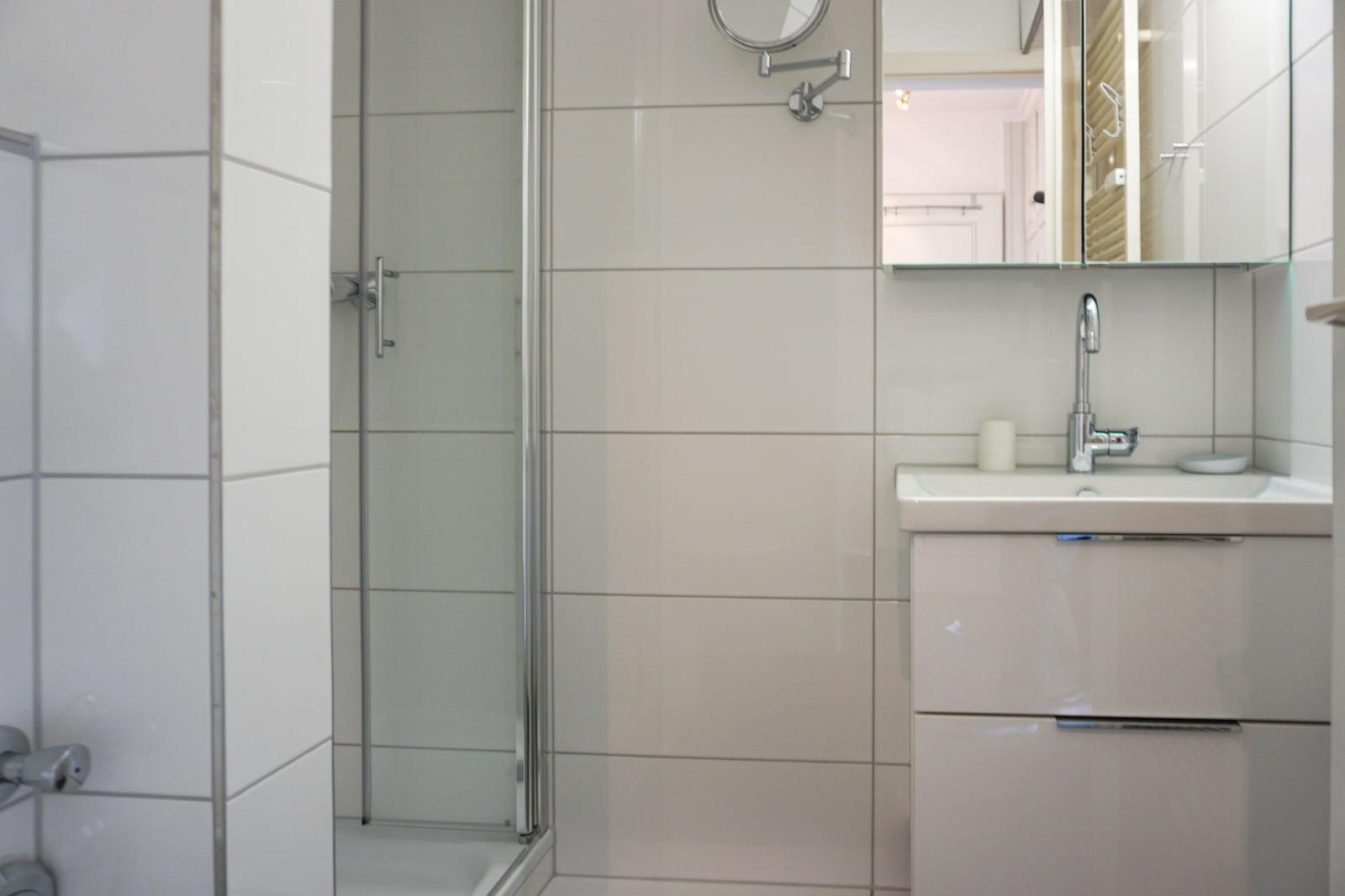 Bathroom with shower, sink, and mirror