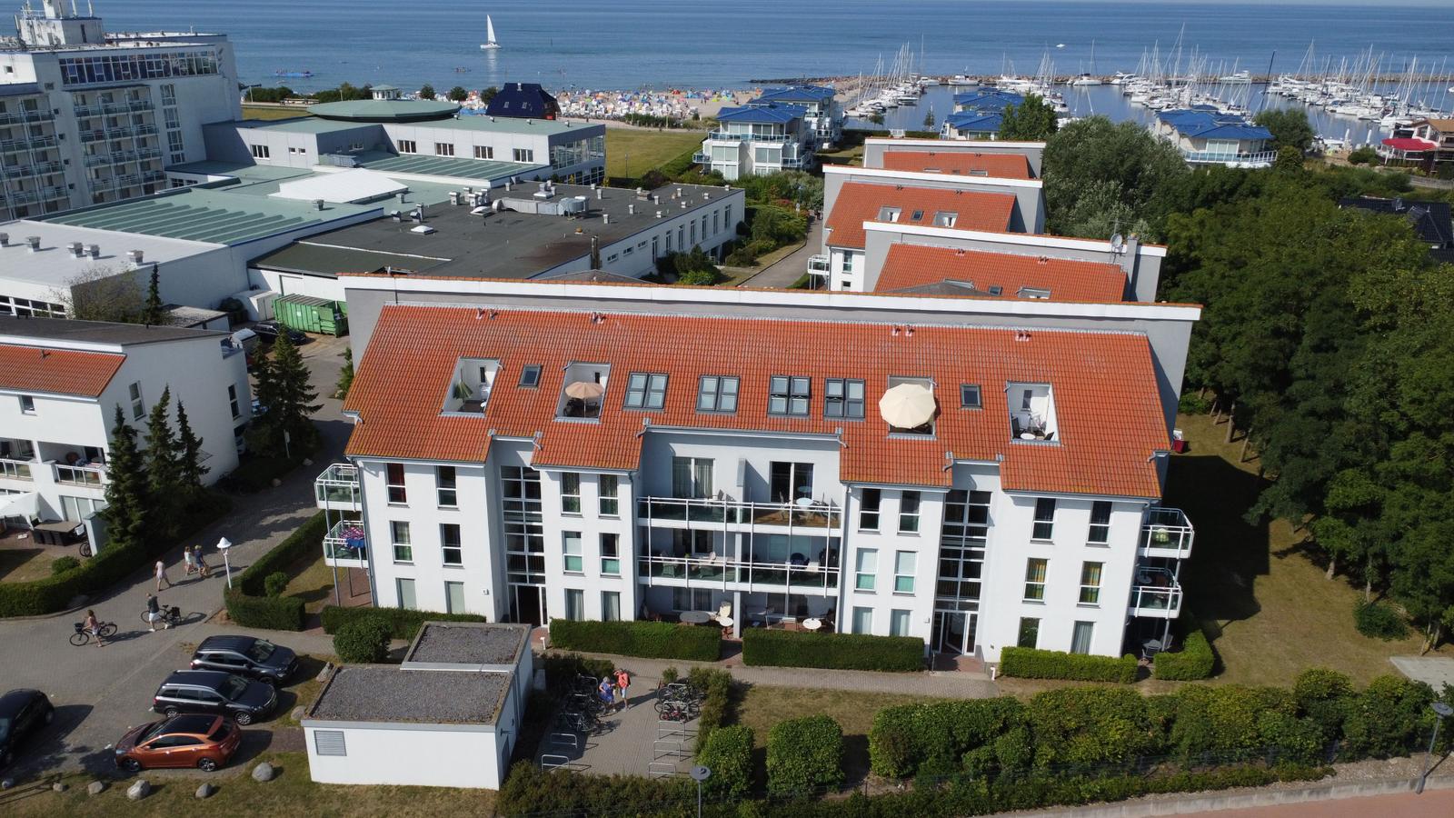 Wohnhaus mit rotem Dach, Blick auf Hafen und Strand.