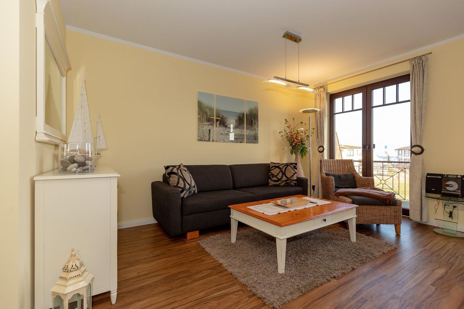 Wohnzimmer mit Sofa, Couchtisch und Blick auf Balkon.