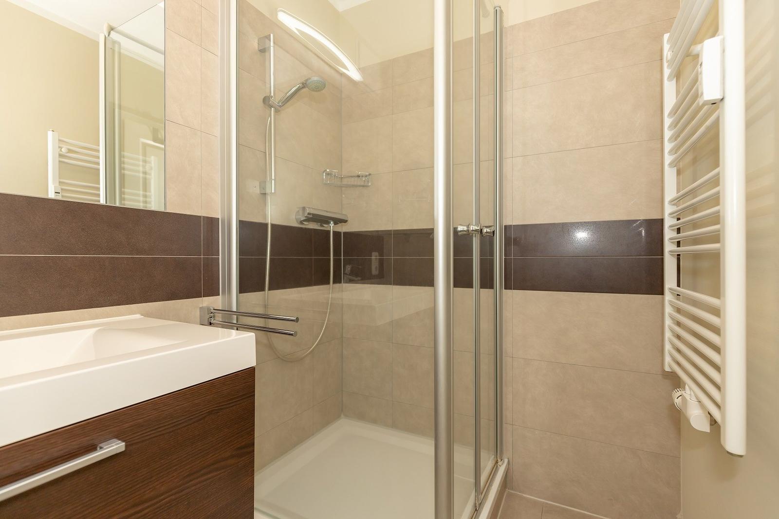 Bad mit Dusche, Waschbecken und Heizkörper