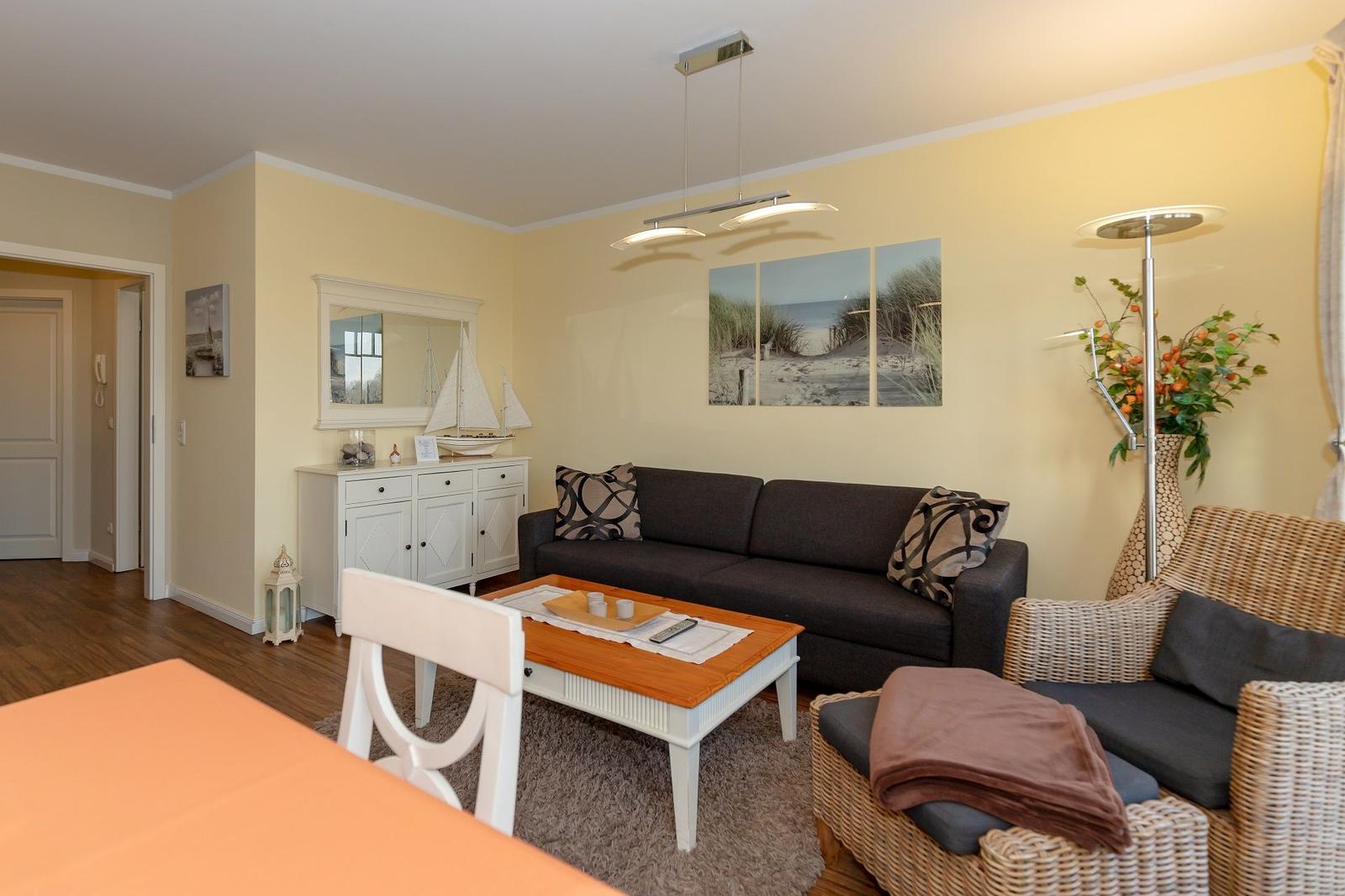 Wohnzimmer mit Sofa, Esstisch, Wandbild und Möbel.