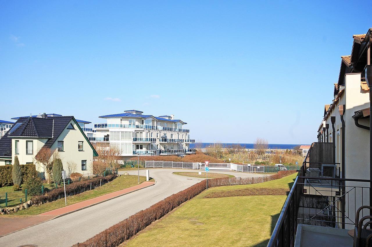 Blick auf Wohnhäuser und den Strand mit blauem Himmel.