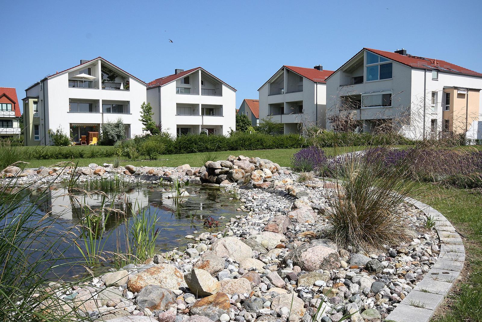 Villa mit Garten und Teich im Hintergrund