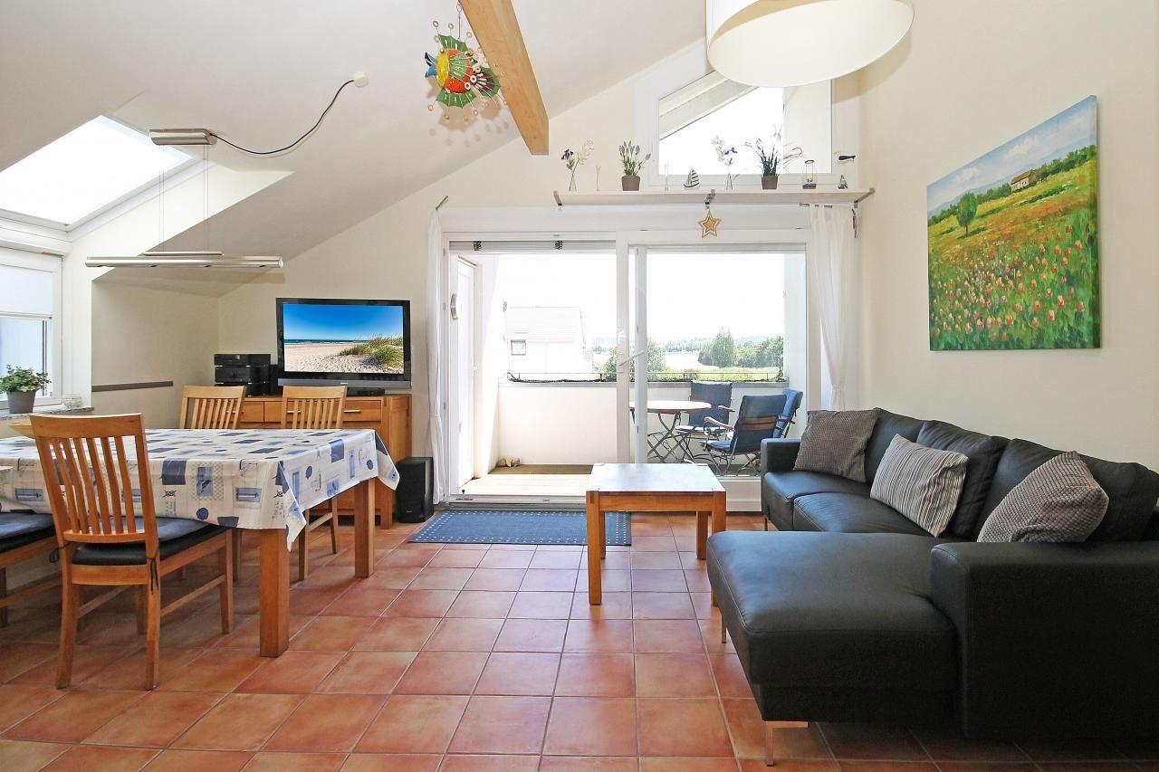 Wohn- und Essbereich mit Sofa, Esstisch und TV. Durchgang zur Terrasse mit Blick.