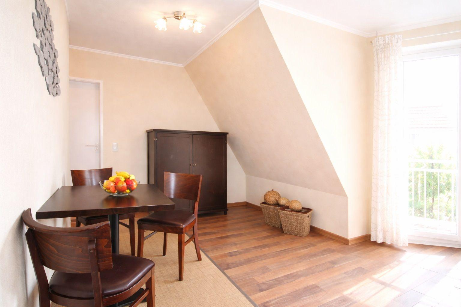 Esszimmer mit Holzfußboden, Tisch, Stühlen und Fenster zur Terrasse.