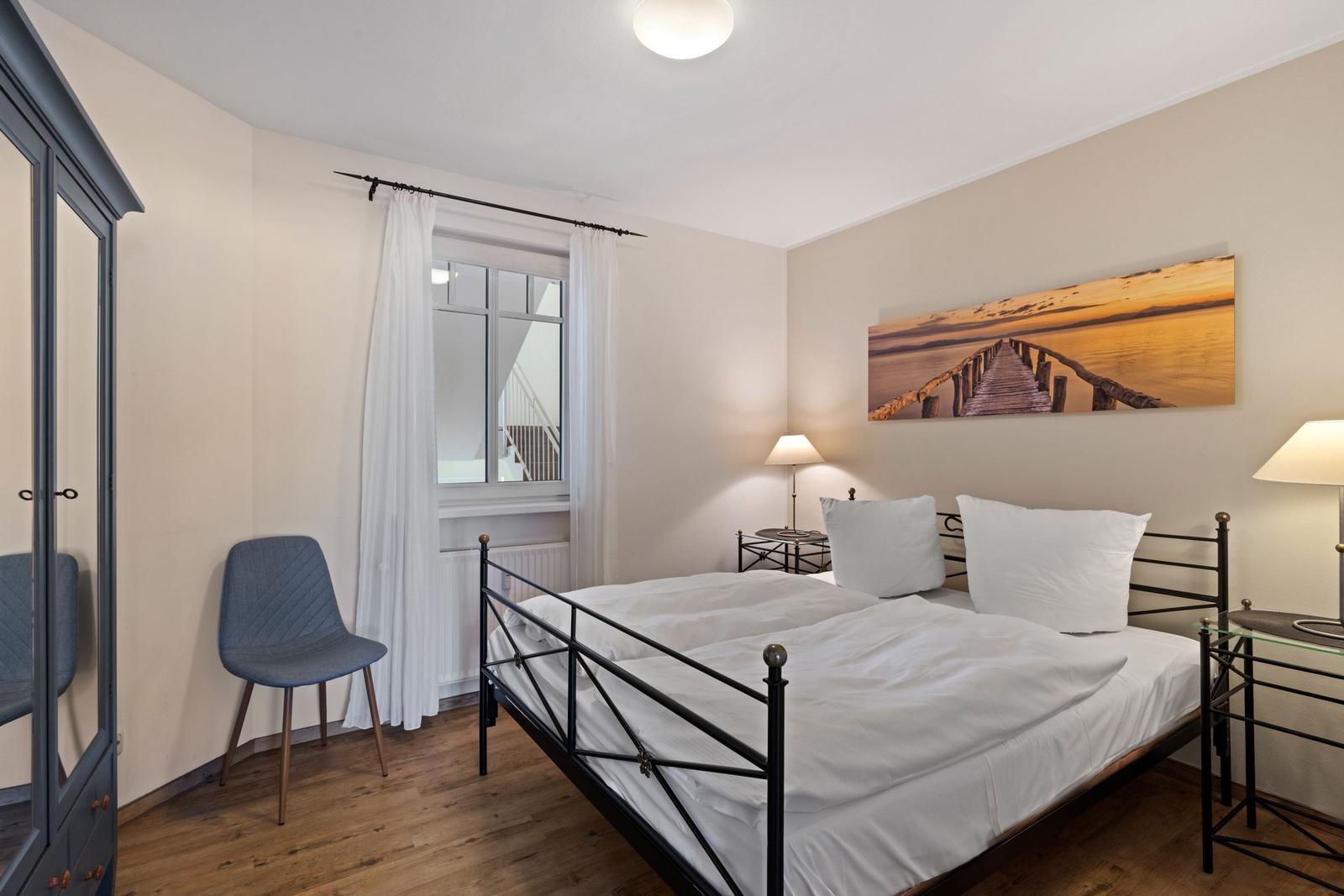 Schlafzimmer mit Doppelbett und Sitzgelegenheit