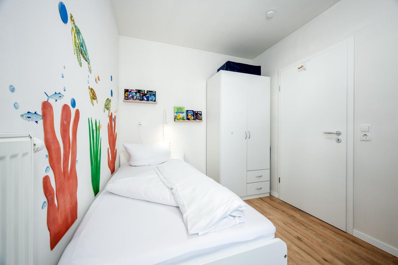 Schlafzimmer mit Einzelbett und Etagenbett