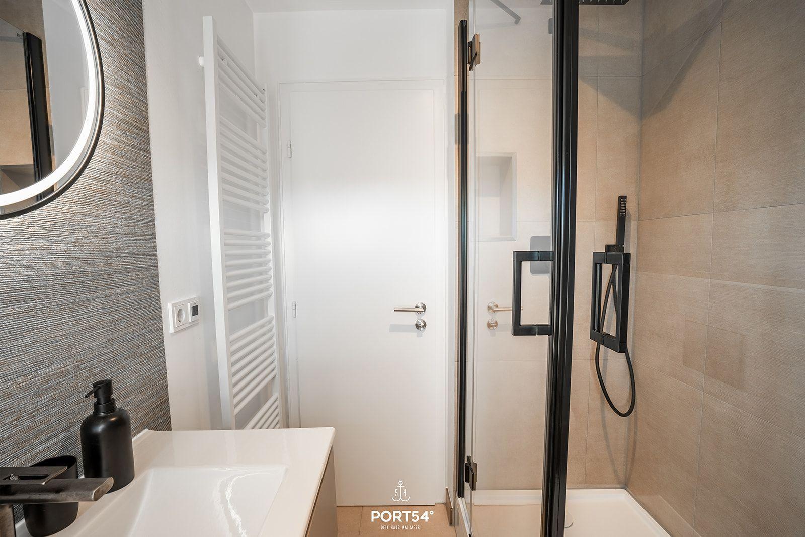 Bathroom with shower, sink, and heater.