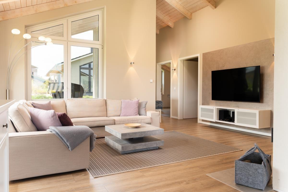 Wohnzimmer mit Sofa, Couchtisch und Fernseher an der Wand.