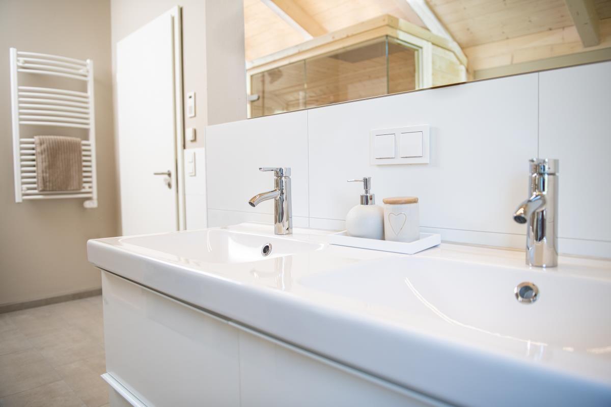Badezimmer mit Doppelwaschbecken, Spiegel und Heizkörper