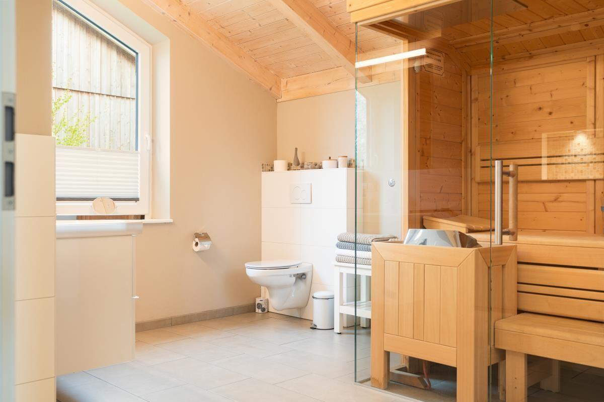 Bad mit Sauna, Toilette und Fenster mit Jalousie.