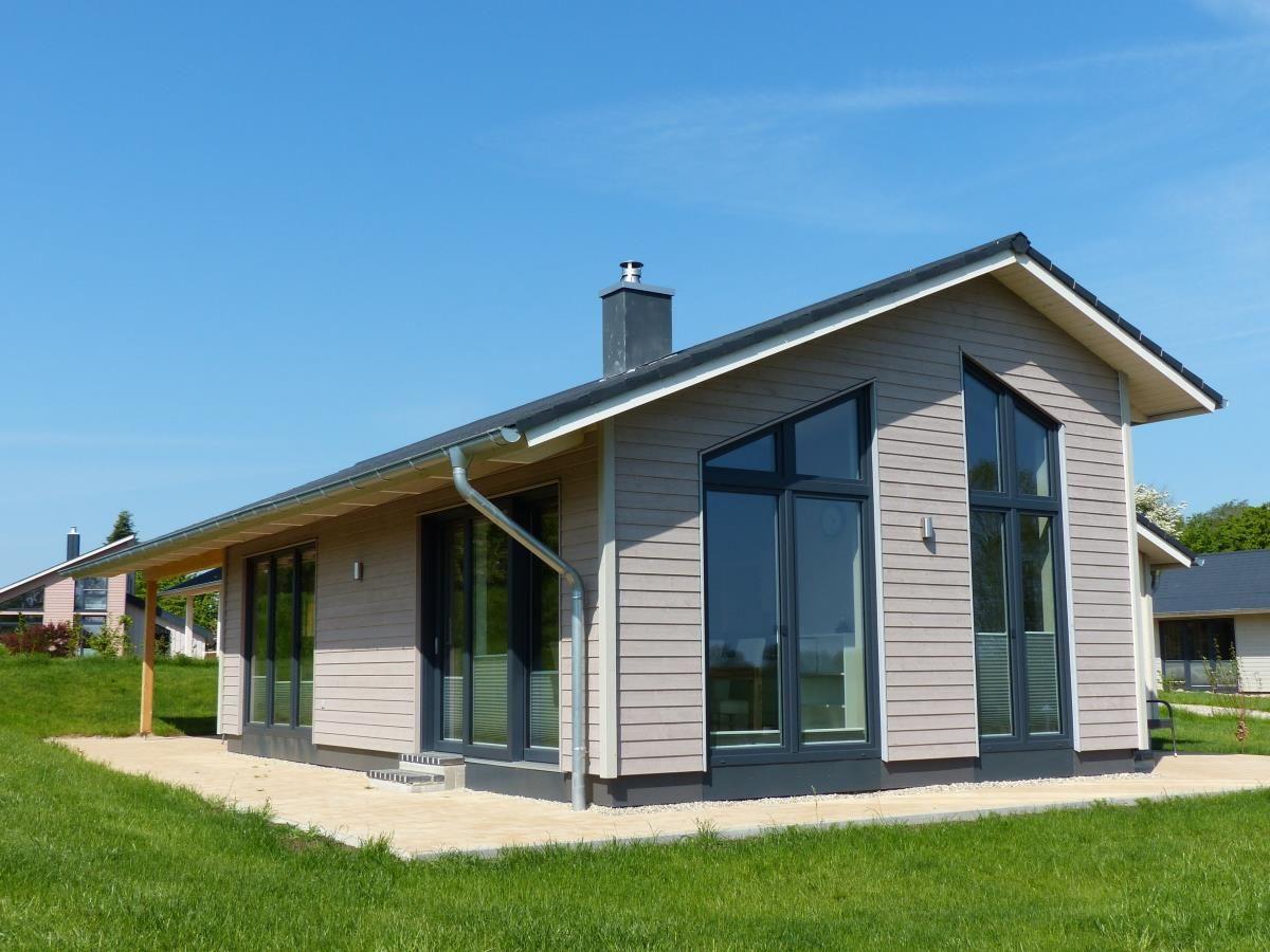 Moderne Villa mit großzügigen Fenstern und Terrasse im Grünen.